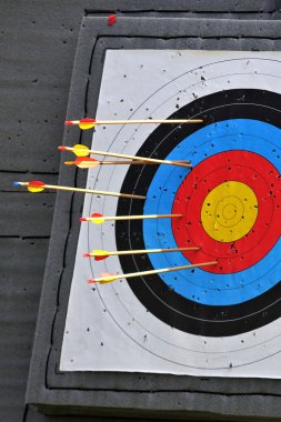 A Round Archery Target with Arrows in it clipart