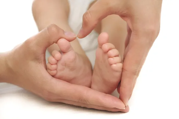 Babyfüße in Mamas Händen — Stockfoto