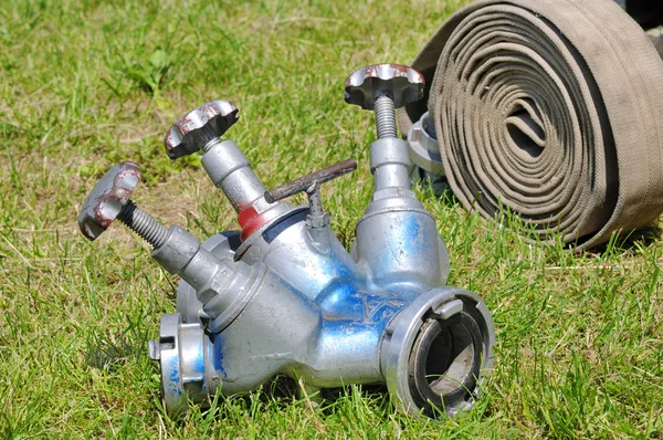 Клапаны и пожарные шланги в действии на траве — стоковое фото