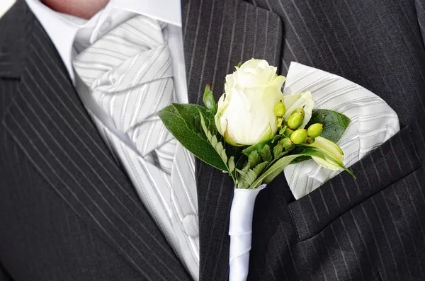 Groom in a wedding dress holding a white rose — Stock Photo, Image
