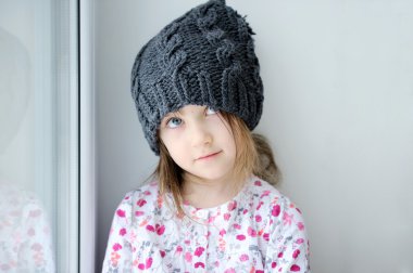 pencerenin yakınındaki koyu gri örgü şapka, sevimli küçük kız