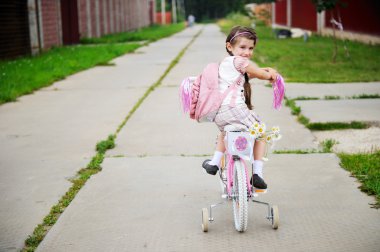 Genç liseli kız pembe sırt çantası bir bisiklet ile