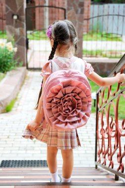Young girl with pink backpack ready for school clipart