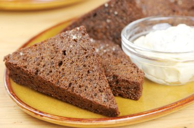 Black bread toasts with garlic sauce on a plate clipart