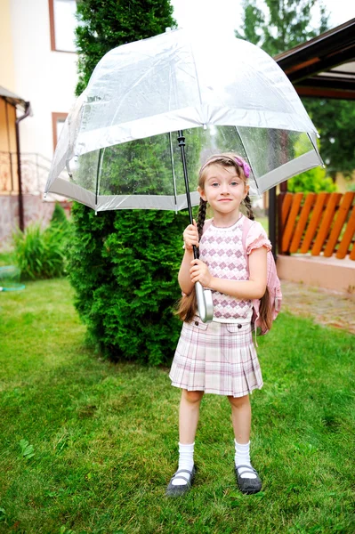 Weinig schoolmeisje met rugzak en paraplu — Stockfoto
