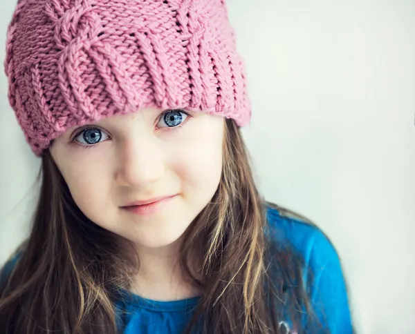 Adorável sorridente menina criança em rosa tricotado chapéu — Fotografia de Stock