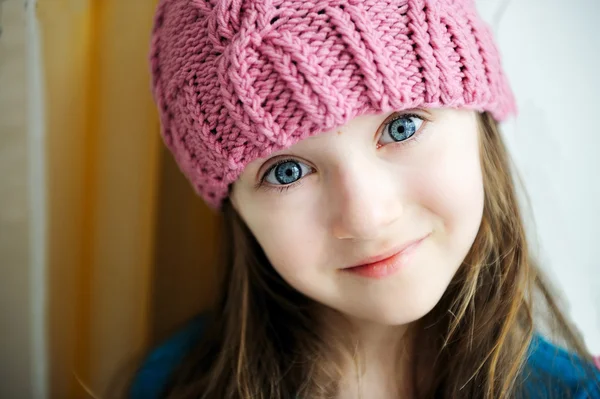 Adorable niña sonriente en sombrero de punto rosa —  Fotos de Stock