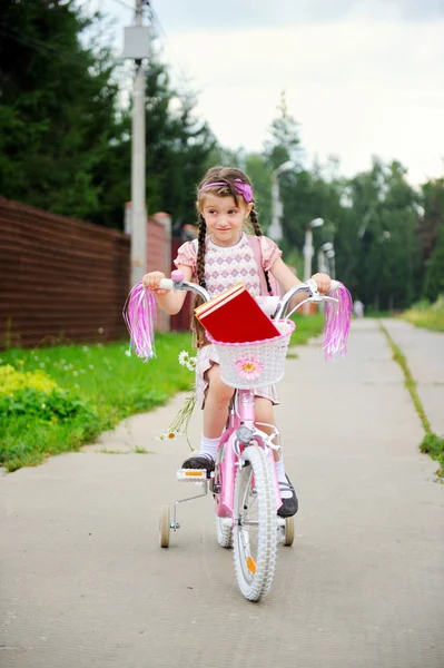 Молода школярка їде рожевий велосипед — стокове фото