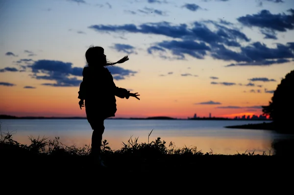 석양에 걷는 아이 여자의 실루엣 — 스톡 사진