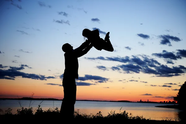 父亲和女儿在夕阳下的剪影 — 图库照片