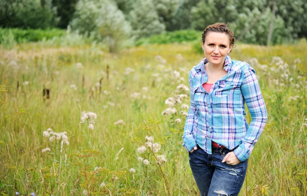 若いきれいな牧草地に立っている女性のポーズ — ストック写真