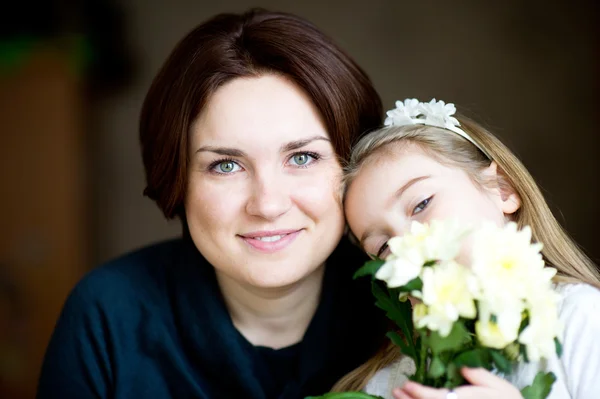 Porträtt av vackra mor och barn med blommor — Stockfoto