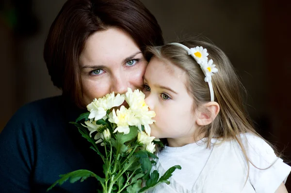 Portret van mooie moeder en kind met bloemen — Stockfoto