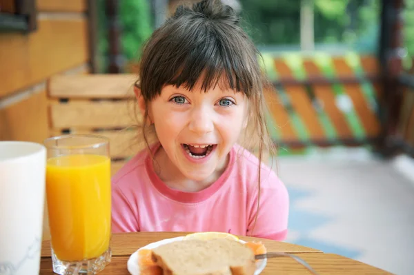 Wondered child girl has a breakfast outdoors — Stock Photo, Image