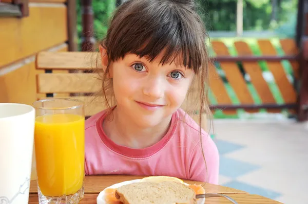 Amazed child girl has a breakfast outdoors — Stock Photo, Image