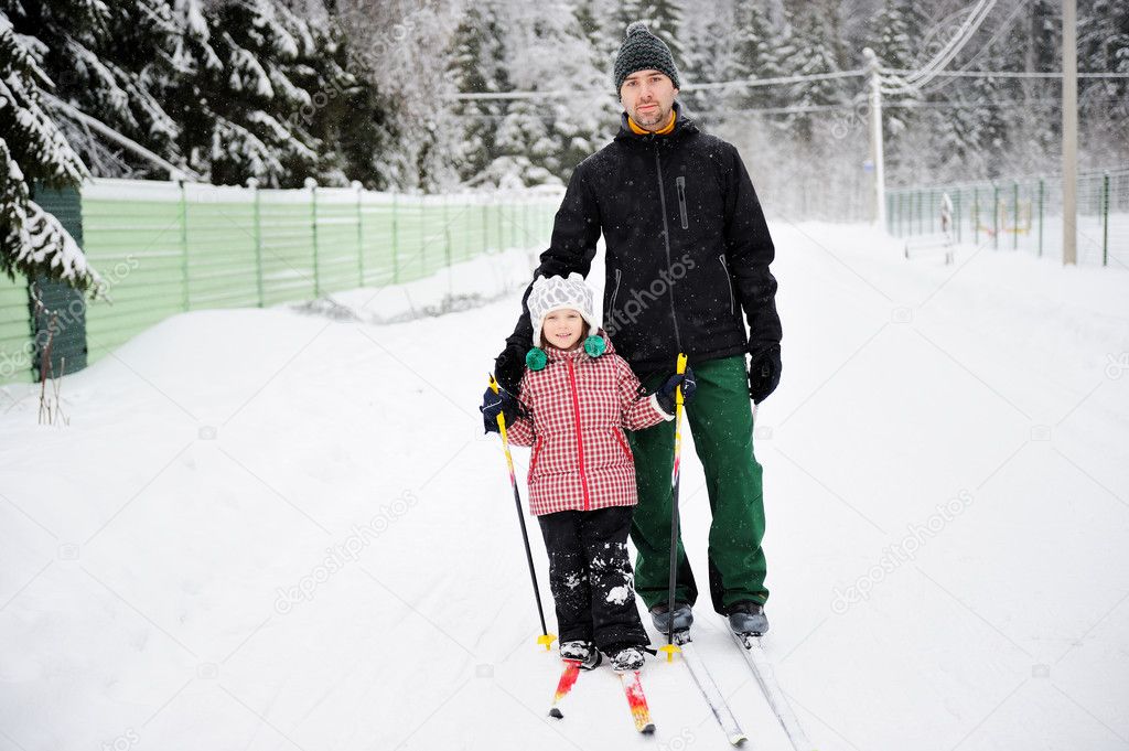 Young father and daughter do Nordic skiing