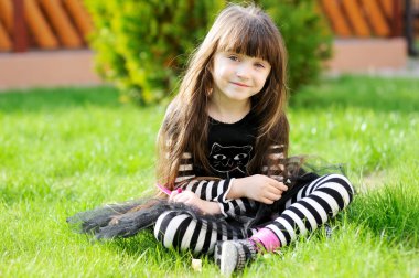 Young girl poses outdoors as a witch on Halloween clipart