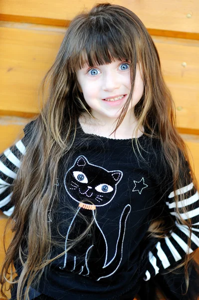 Young girl outdoors acts as a black cat on Halloween — Stock Photo, Image