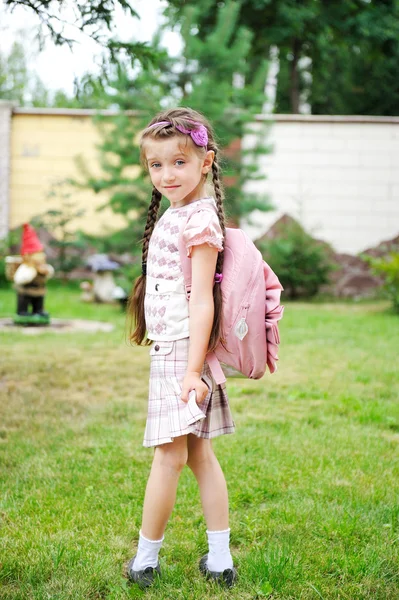 Молодая школьница с розовым рюкзаком позирует на открытом воздухе — стоковое фото
