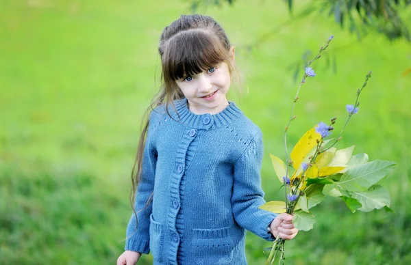 Schattig kind meisje vormt buiten in de blauwe trui — Stockfoto