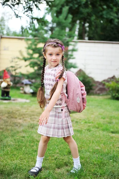 Ung skolflicka med rosa ryggsäck poserar utomhus — Stockfoto