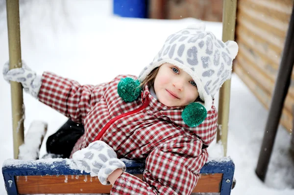 Adorable child girl enjoys seesaw in winter — Stock Photo, Image