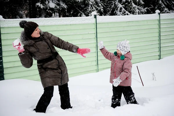 Jovem mãe e filha se divertem na neve — Fotografia de Stock
