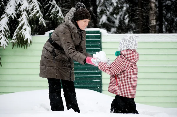 Jovem mãe e filha se divertem na neve — Fotografia de Stock