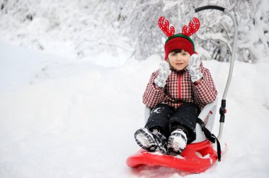 schattig kind meisje in gehoornde hoed slee in sneeuw