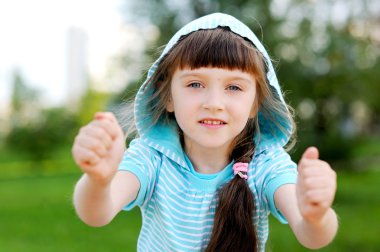 Outdoor portrait of cute child girl in blue jacket clipart