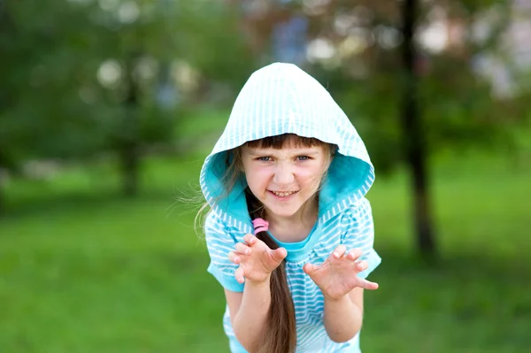 Schattig kind meisje vormt buitenshuis met eng gezicht — Stockfoto