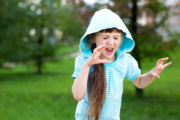 Menina bonito posa ao ar livre com rosto assustador — Fotografia de Stock