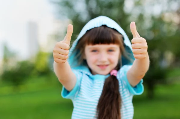 Outdoor portrait of cute child girl with thumbs up — Stock Photo, Image