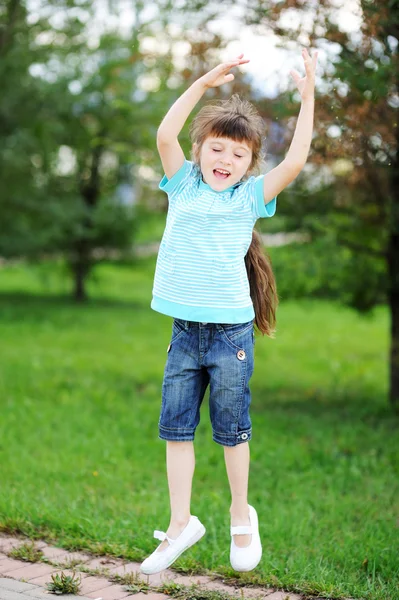 Happy child girl is jumping in the air outdoors — Stock Photo, Image