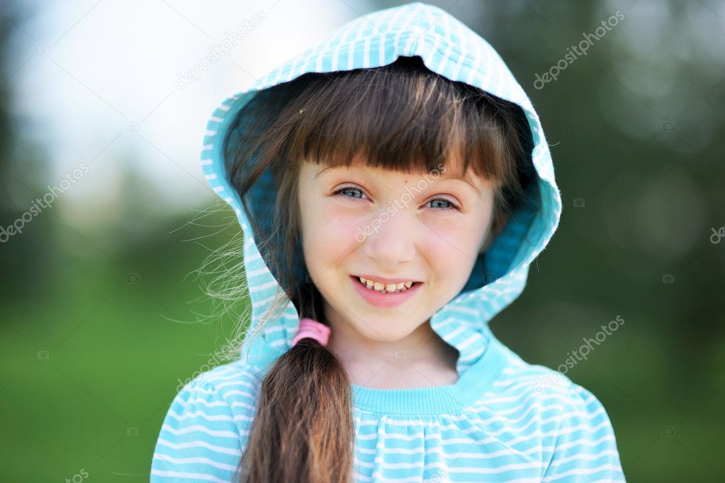 Outdoor portrait of cute child girl in blue jacket