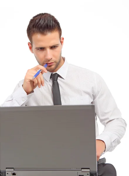 Zakenman denken met een pen in de voorkant van een laptop — Stockfoto