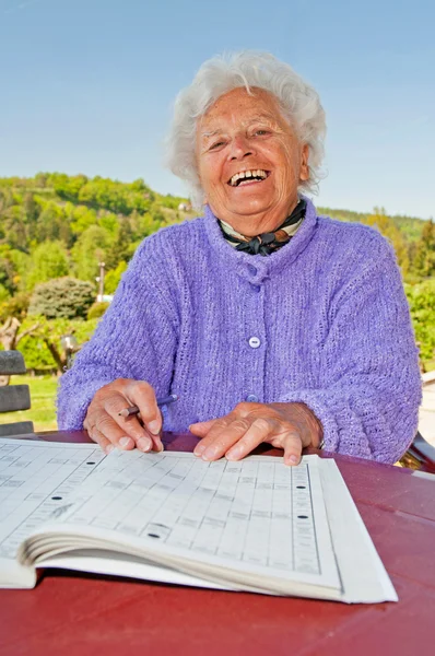 Seniorin beim Kreuzworträtsel — Stockfoto