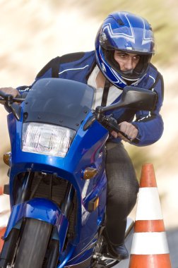 Man passing safety cone on his motorcycle clipart