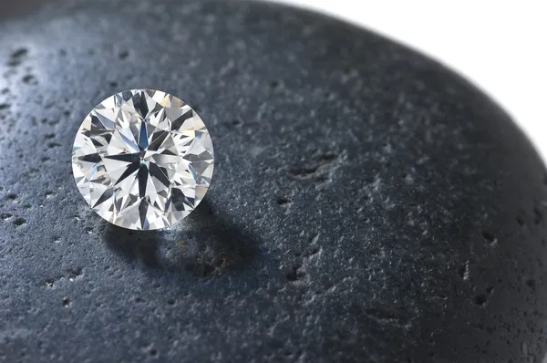 Nahaufnahme eines Diamanten auf dem schwarzen Stein — Stockfoto