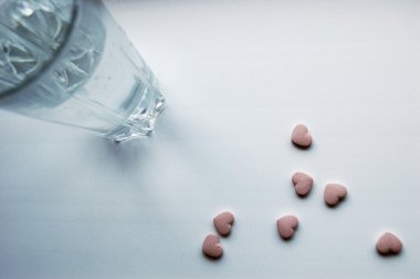 The glass of water and heart-shaped tablets clipart