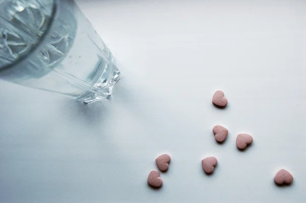 stock image The glass of water and heart-shaped tablets
