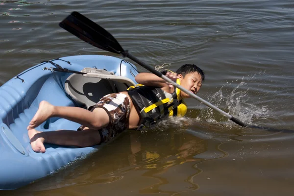 Niño cayendo de un kayak Imagen De Stock