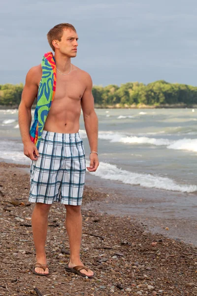 Unga vuxna manliga simmare på en strand. — Stockfoto