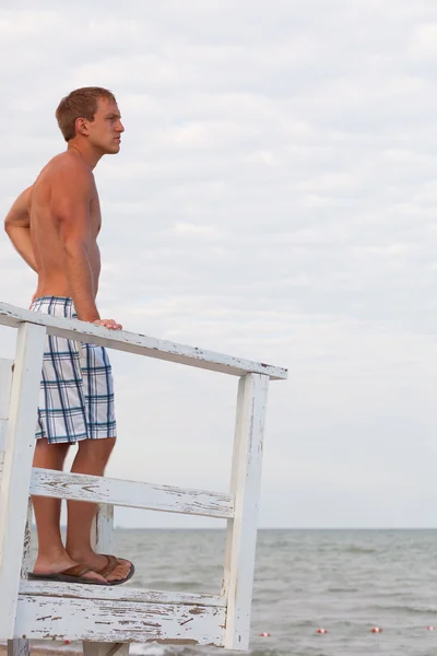 Jonge volwassen mannelijke zwemmer op een strand. — Stockfoto