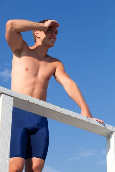 Jonge volwassen mannelijke zwemmer op een strand. — Stockfoto