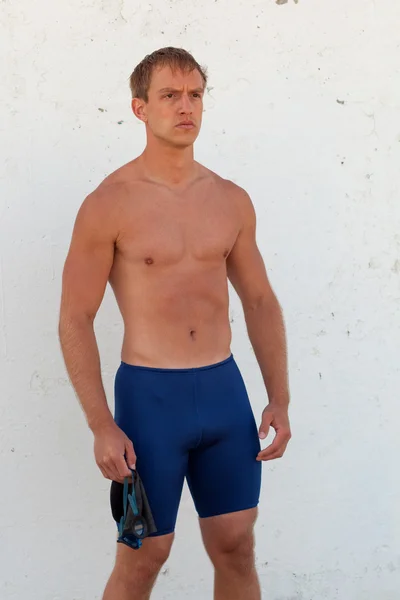 Nadador masculino, do lado de fora, em frente a uma parede branca . — Fotografia de Stock