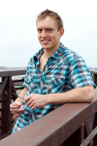 stock image Young man on bridge on a cloudy day.