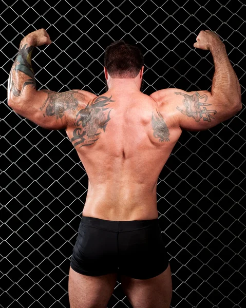 Fisiculturista posando na frente do elo da cadeia . — Fotografia de Stock
