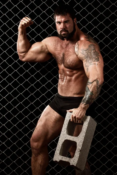 Bodybuilder posant devant le maillon de la chaîne . — Photo