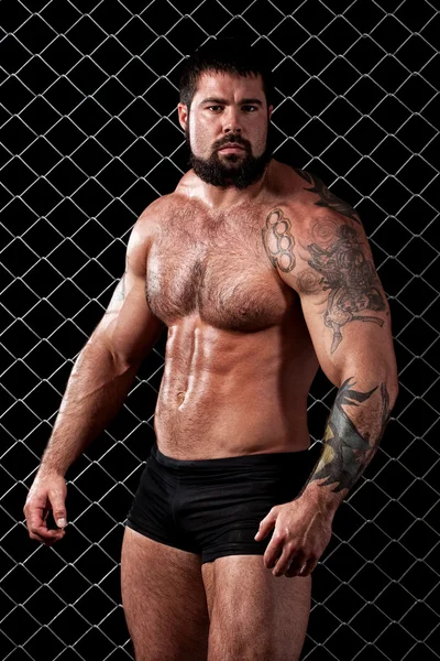 Bodybuilder posant devant le maillon de la chaîne . — Photo